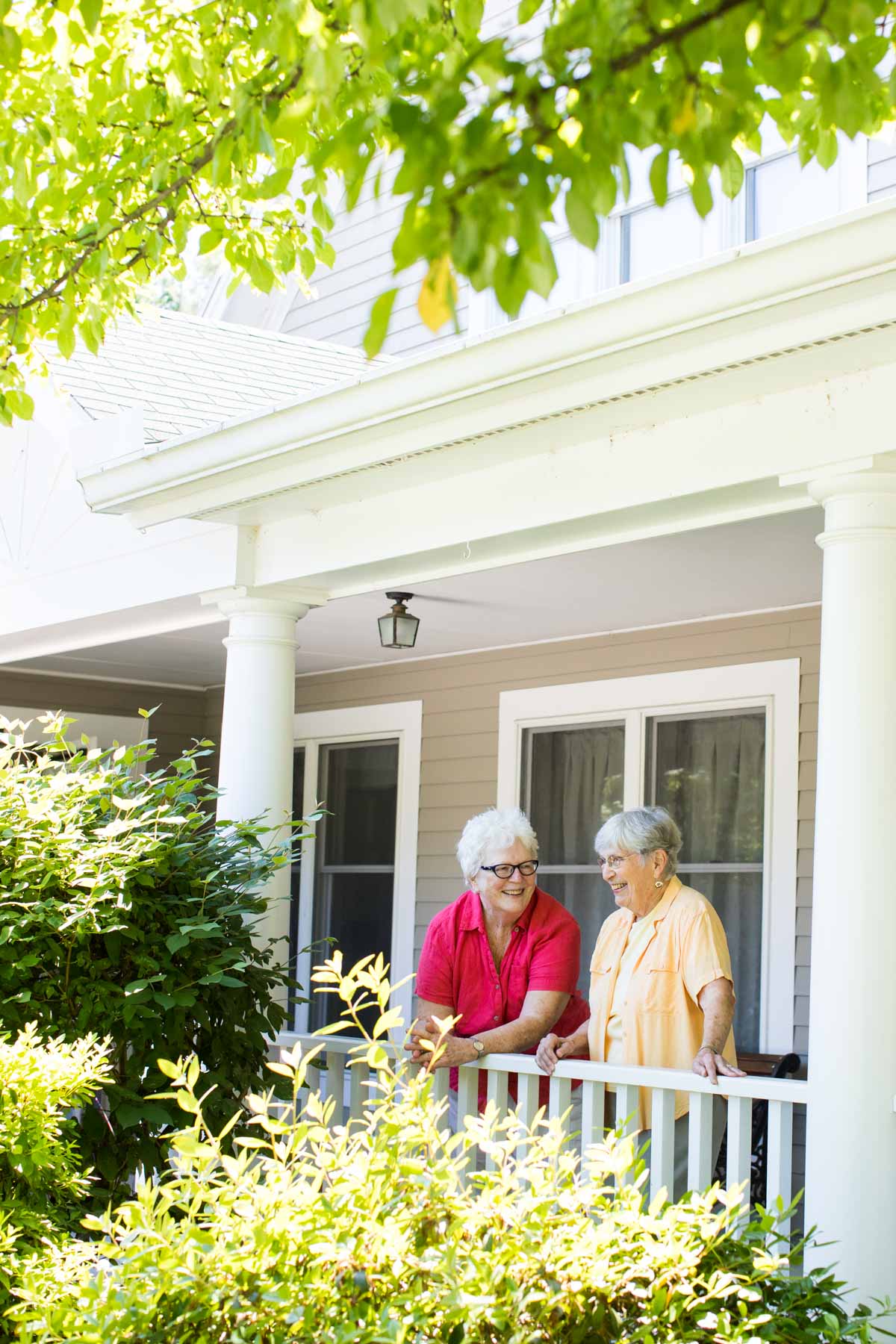 two residents talking on porch