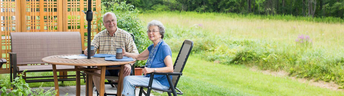 two residents sitting at a table on patio