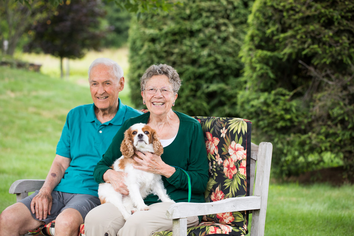 two residents with dog on bench